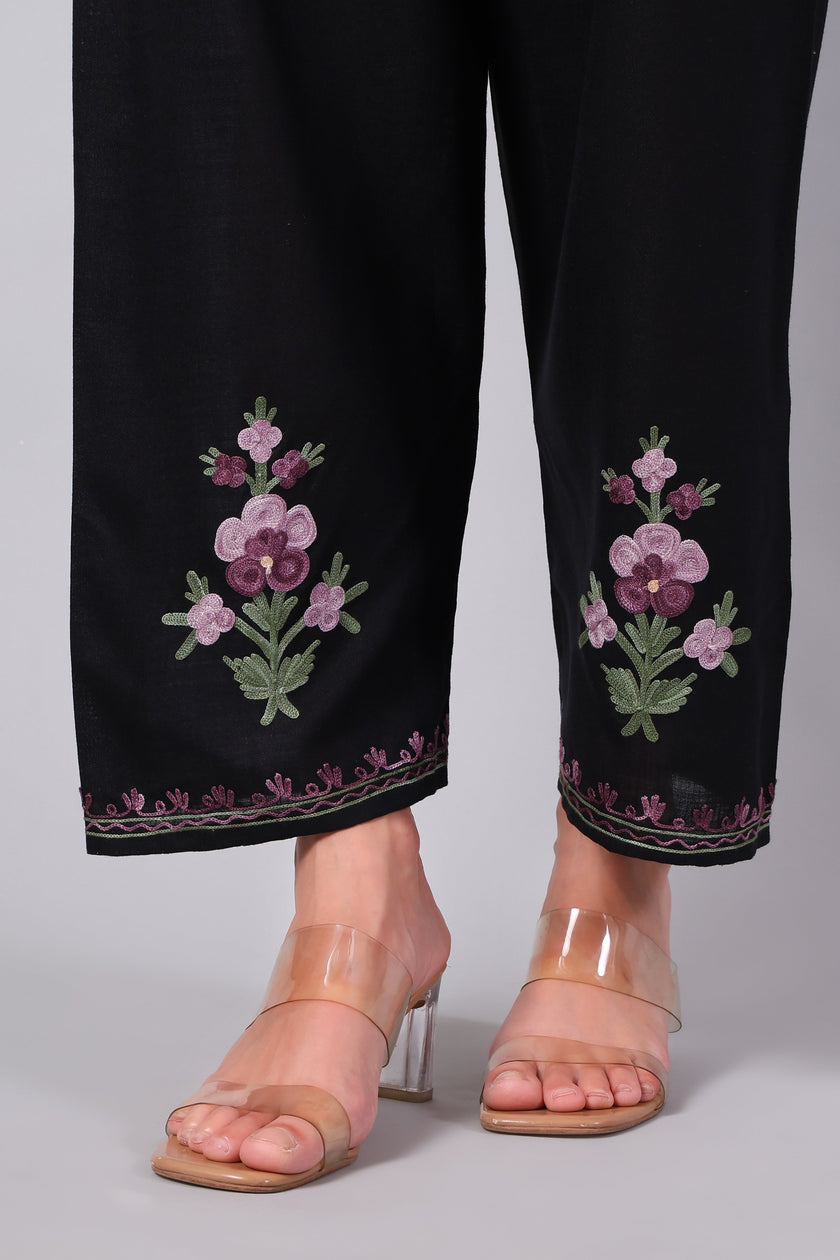 Detailed view of pink floral Aari embroidery on black co-ord set pants