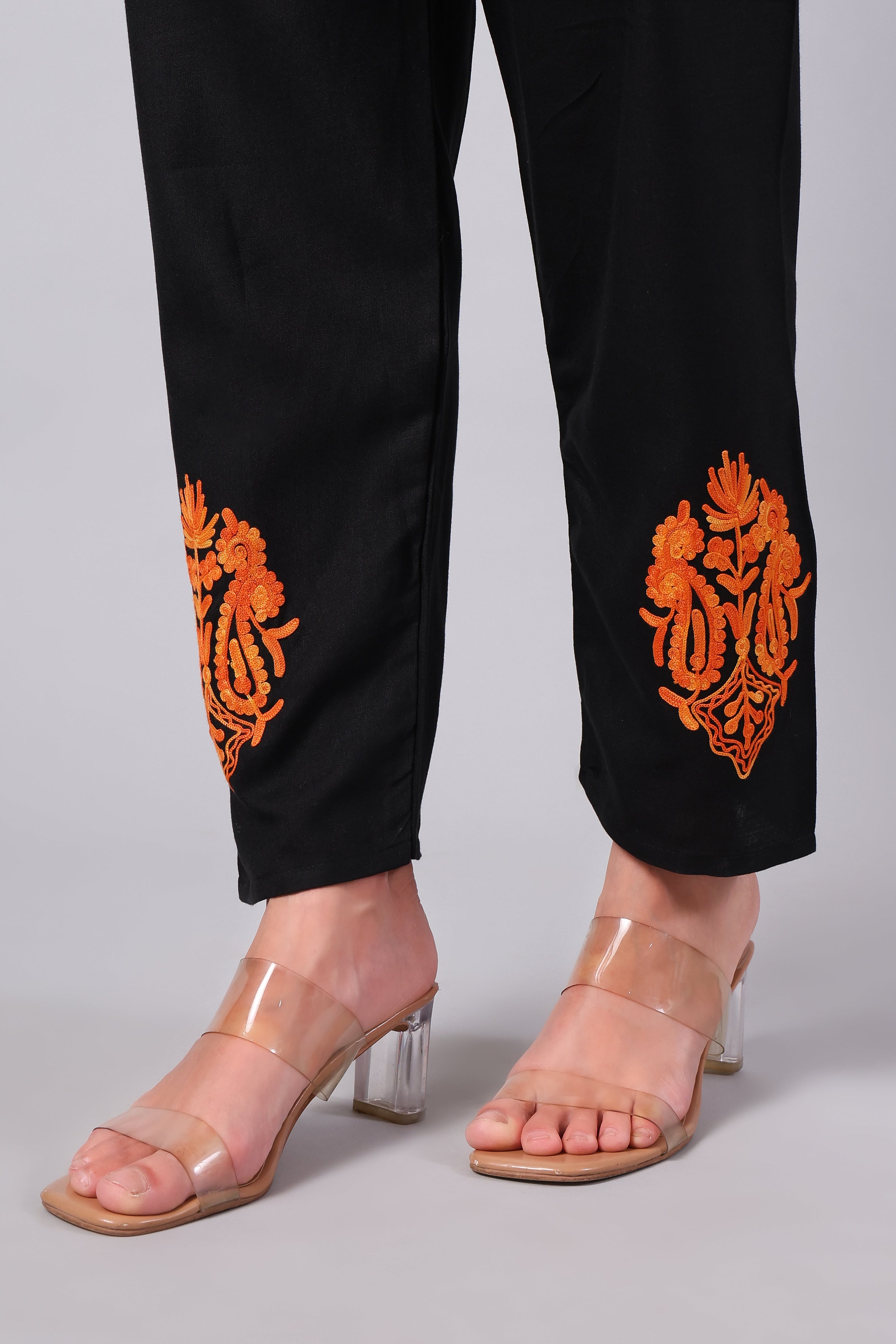 Detailed view of burnt orange Aari embroidery on black co-ord set pants