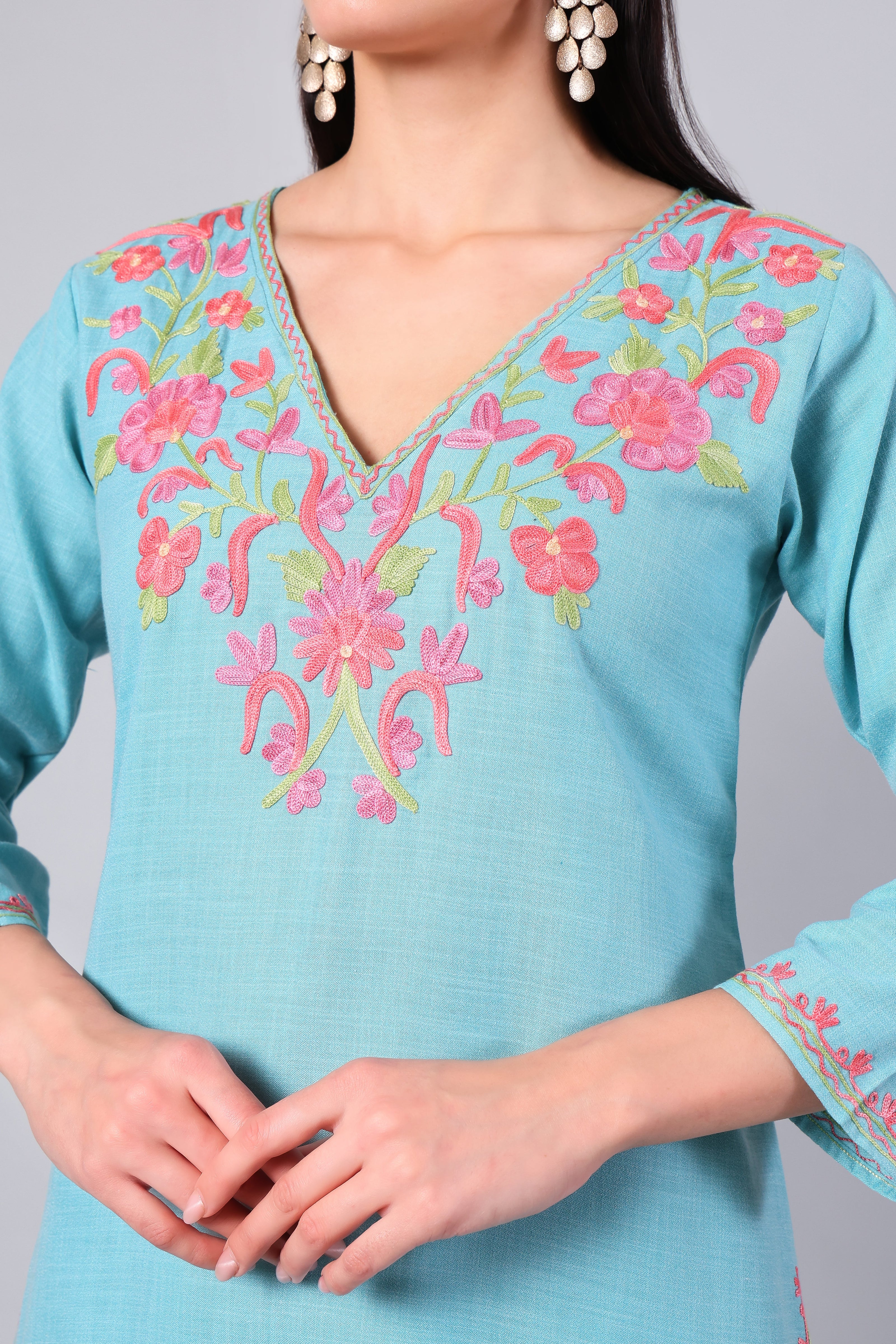 Close-up of coral pink Kashmiri Aari embroidery on aqua blue co-ord set neckline