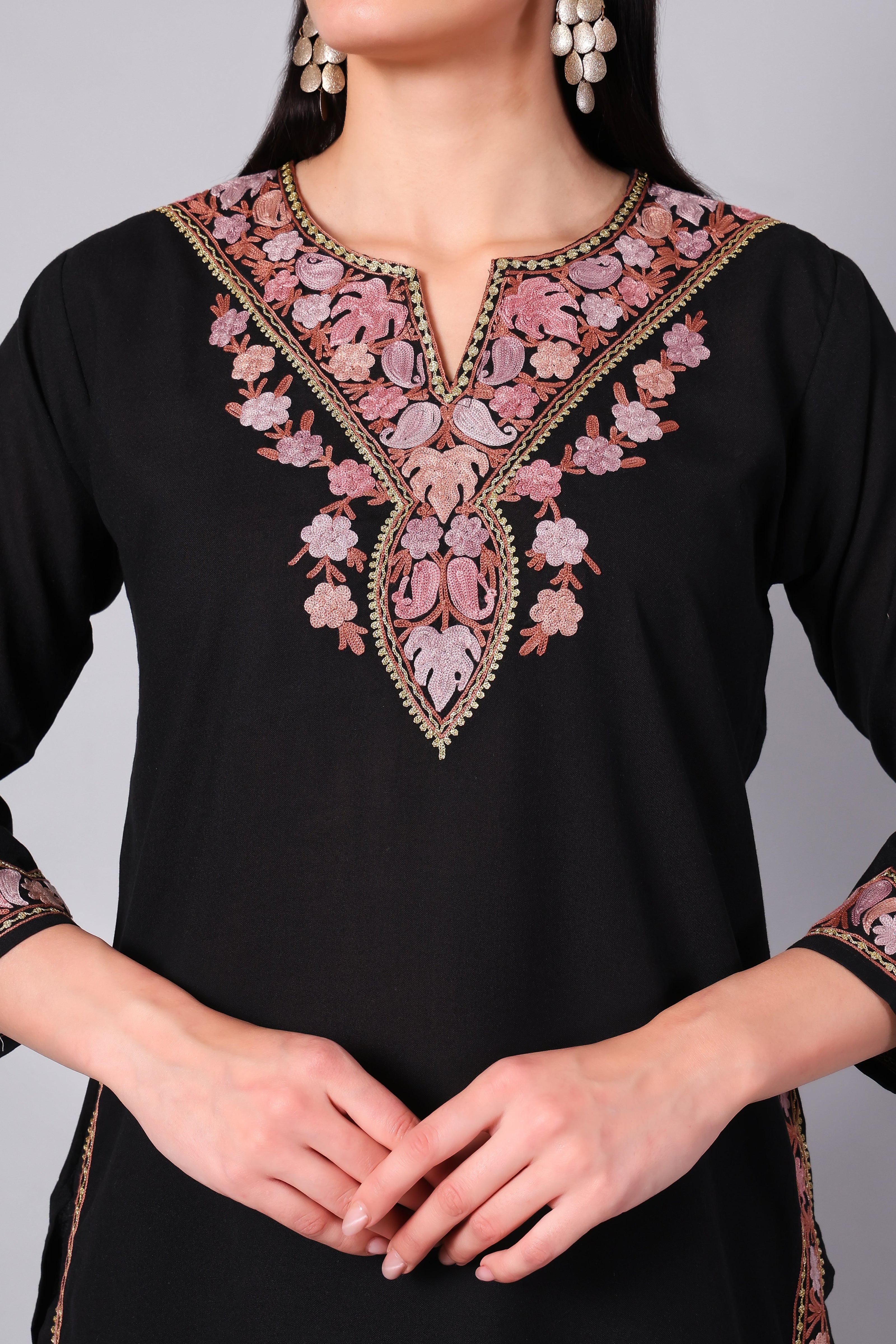 Close-up of intricate pink Kashmiri Aari embroidery on neckline of black co-ord set