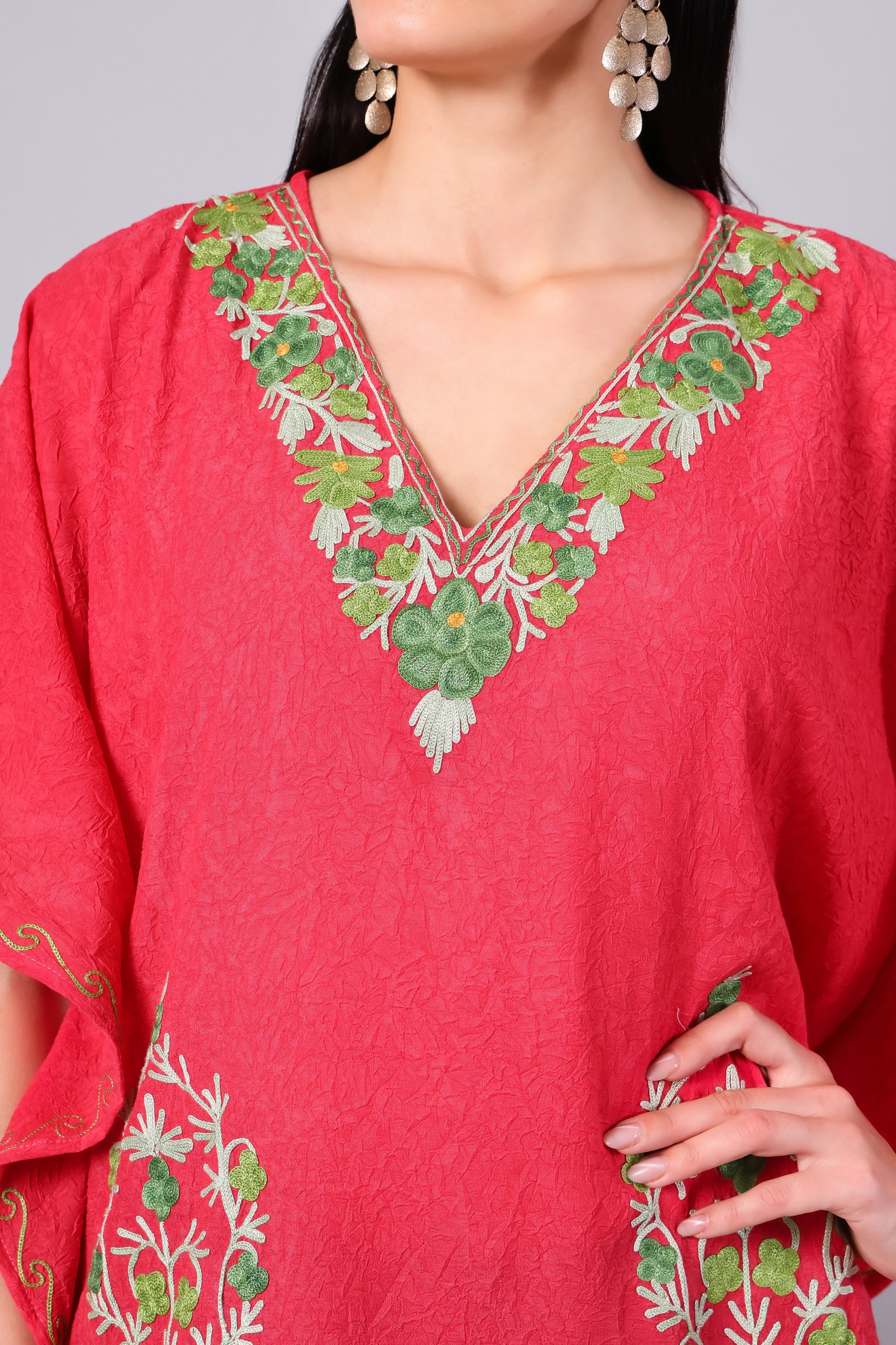Close up of multicolor floral embroidery on coral red kaftan neckline