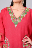 Close up of multicolor floral embroidery on coral red kaftan neckline