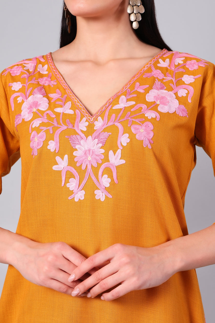 Close-up of blush pink Kashmiri Aari embroidery on saffron co-ord set neckline