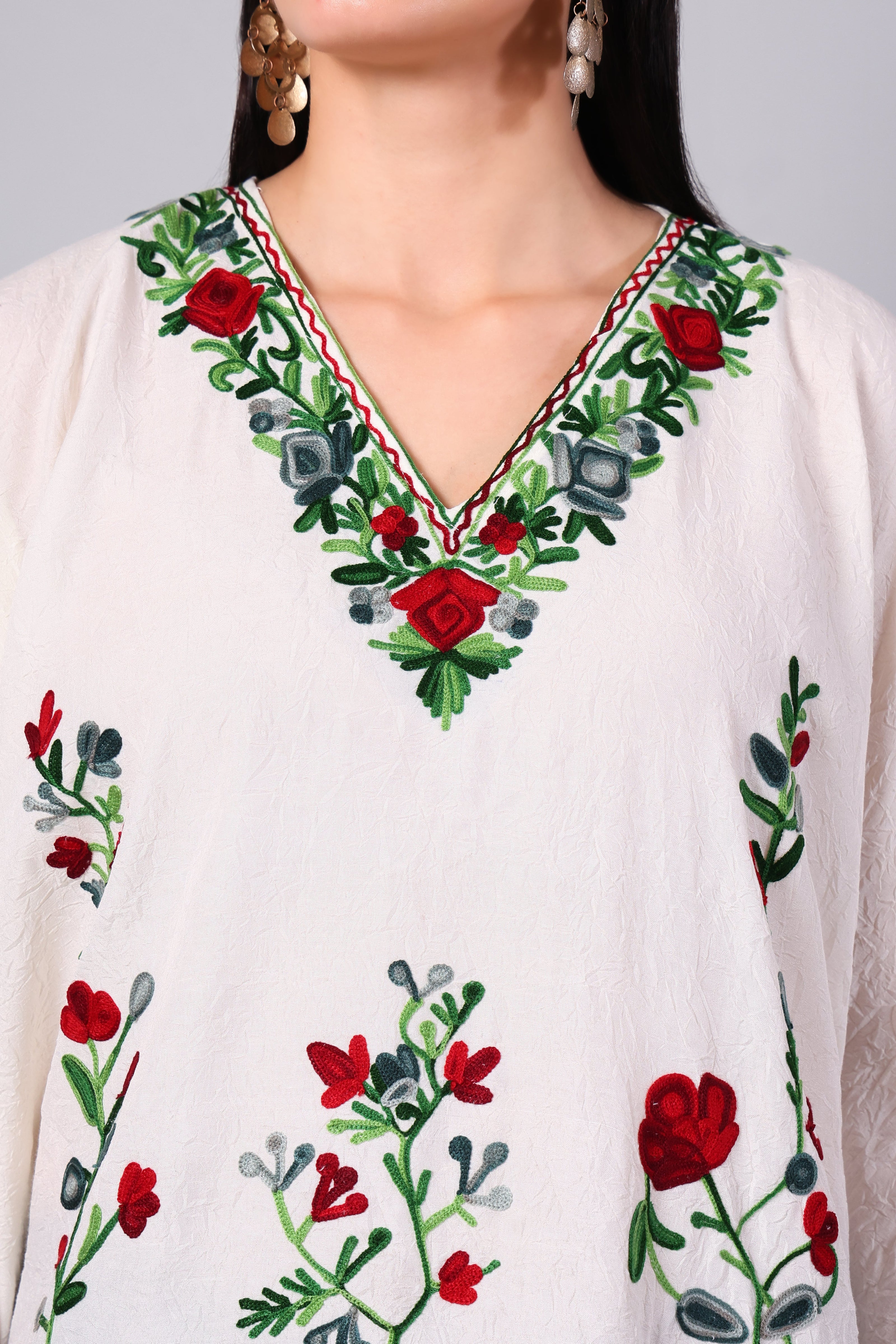 Close-up of red floral Kashmiri Aari embroidery on white kaftan neckline